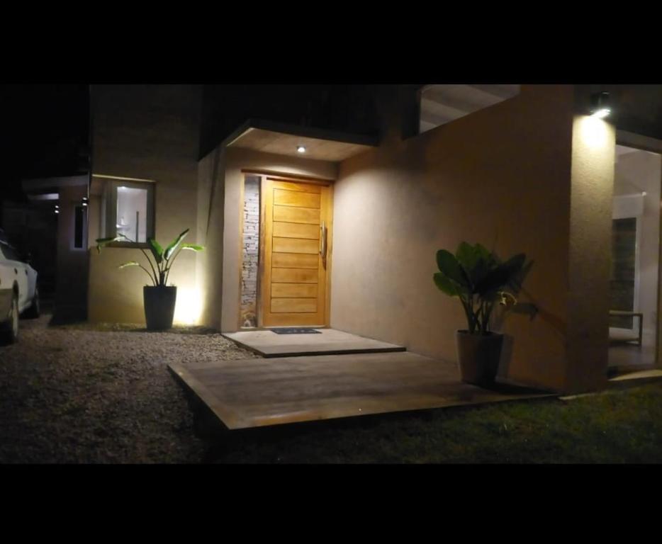a room with a wooden door and two potted plants at Casa de Flia in Villa Gesell
