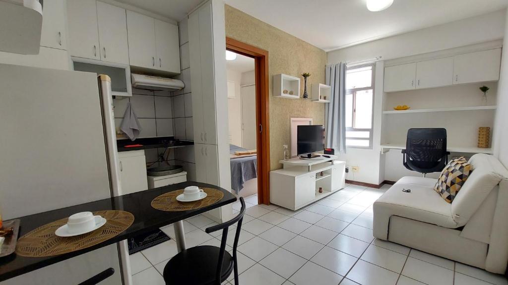 ブラジリアにあるAconchegante proxima ao parque e ao setor hospitalarのキッチンとテーブルとソファのあるリビングルーム