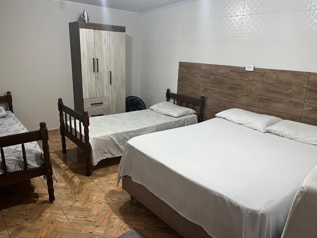 a bedroom with two twin beds and a cabinet at Casa Alto da Glória in Curitiba