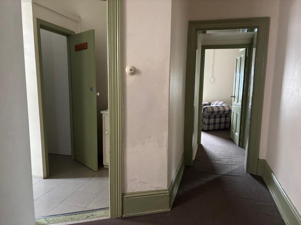 a hallway with two open doors and a mirror at Echuca Hotel in Echuca