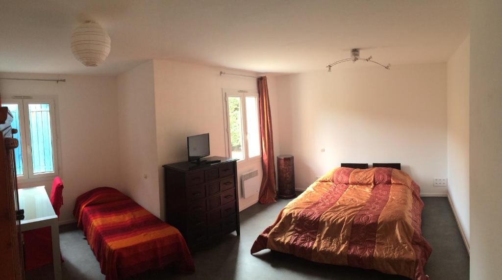 サン・パレ・シュル・メールにあるChambres Les Passifloresのベッドルーム1室(ベッド2台、ドレッサー、テレビ付)