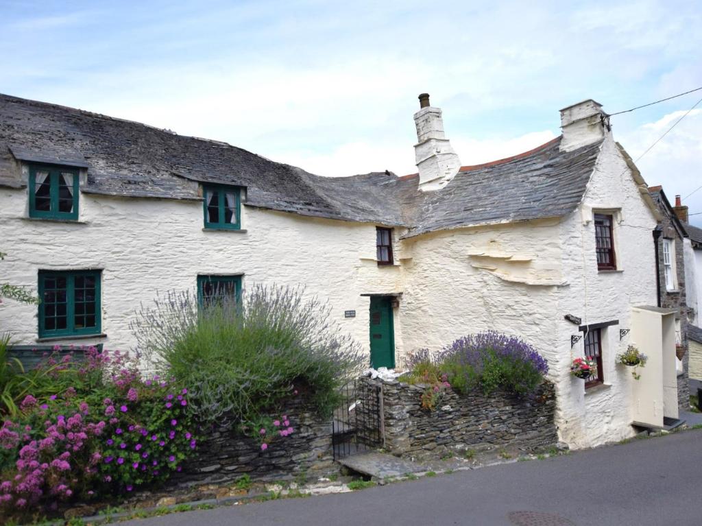 a white house with flowers in front of it at 3 Bed in Boscastle 75145 in Boscastle