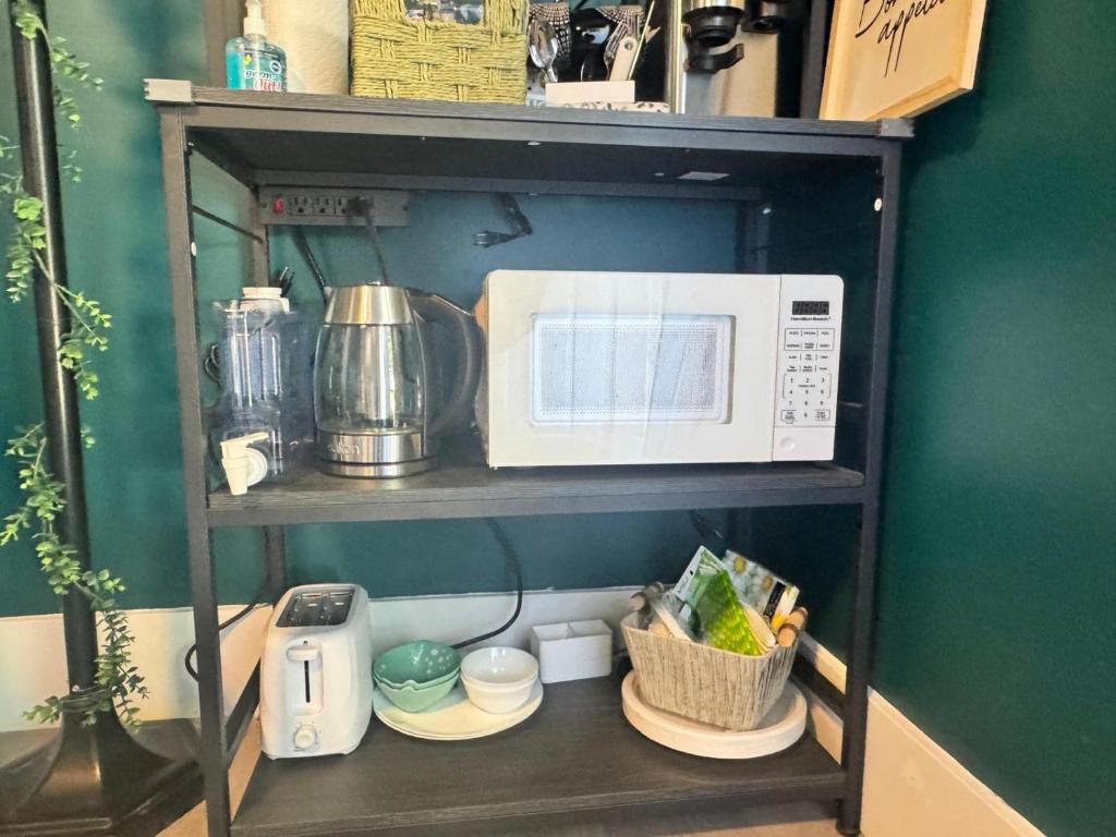 a shelf with a microwave and other kitchen items on it at Dream room in Moncton