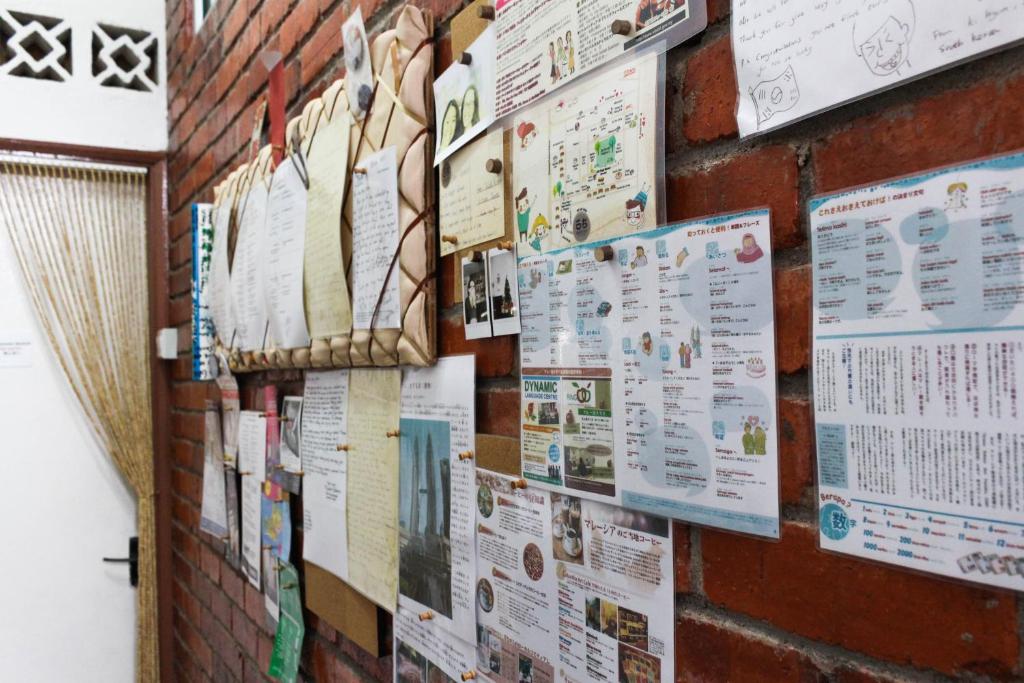 a brick wall with posters and signs on it at Project Uchi SS2 in Petaling Jaya