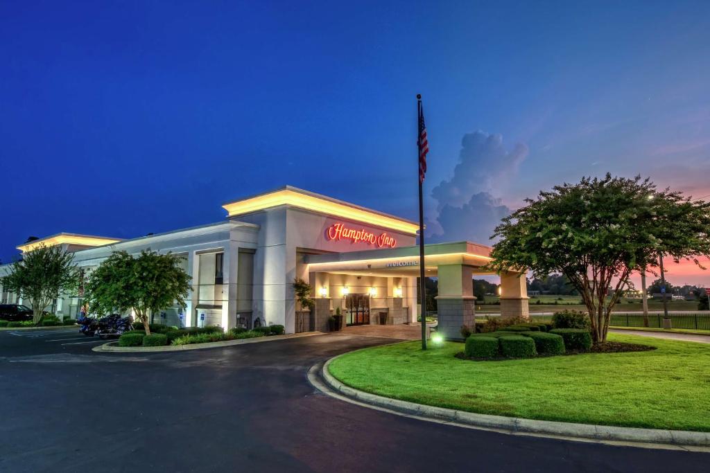 a hotel with a flag in front of a building at Hampton Inn Corinth in Corinth