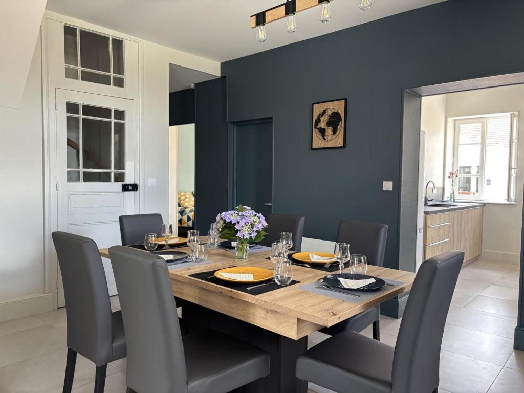 a dining room with a wooden table and chairs at Gîte familial au cœur de l'Allier, proche du PAL - FR-1-489-587 in Saligny-sur-Roudon