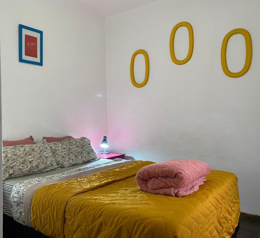 a bedroom with a bed with a yellow blanket on it at Plazoleta Apartamento in Córdoba