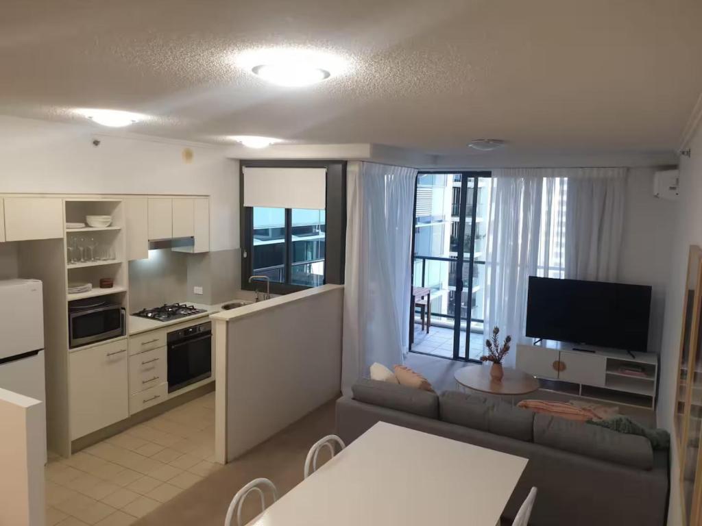 Una cocina y una sala de estar con un sofá y una mesa. en Open 1 Bedroom Apartment in Brisbane City, en Brisbane