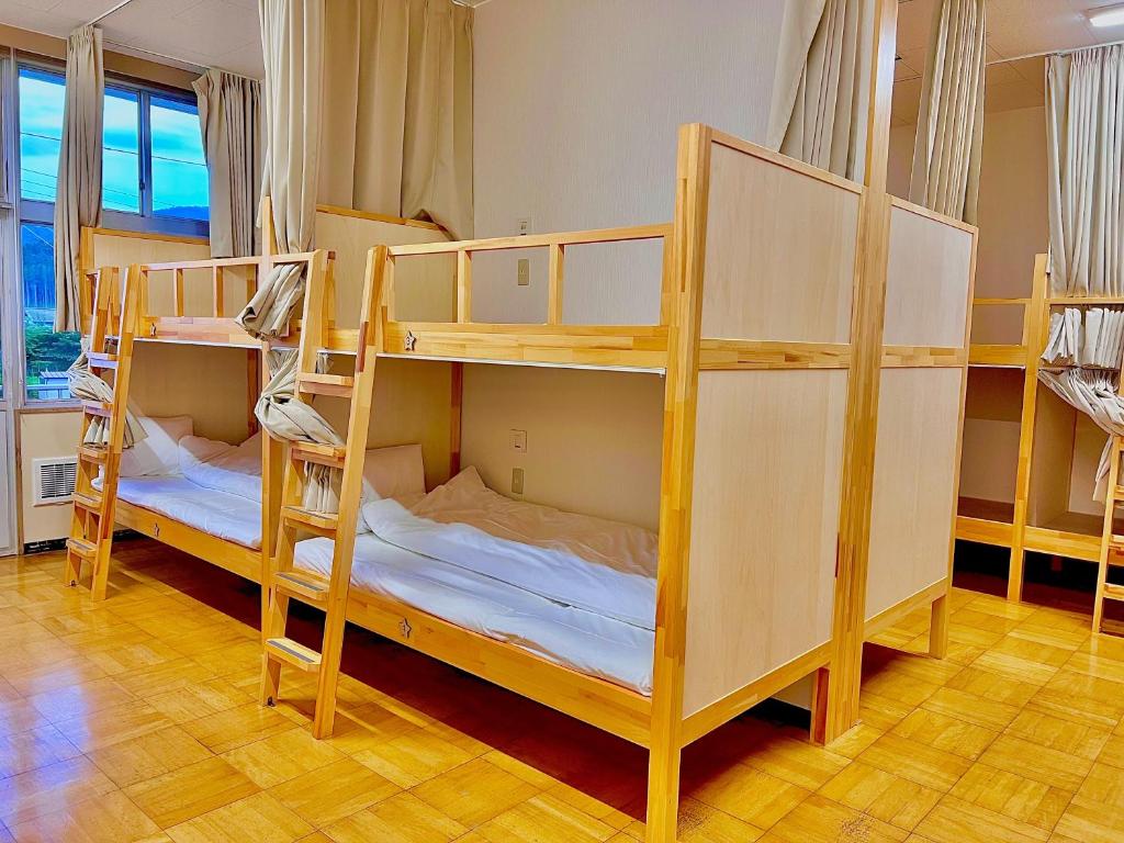 a room with three bunk beds in a room at 三陸アクティブ in Ōfunato