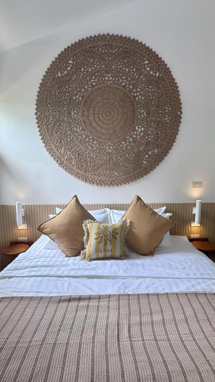 a bedroom with a bed with a large painting on the wall at Villa Sun, Villa 19 in Chaweng Noi Beach