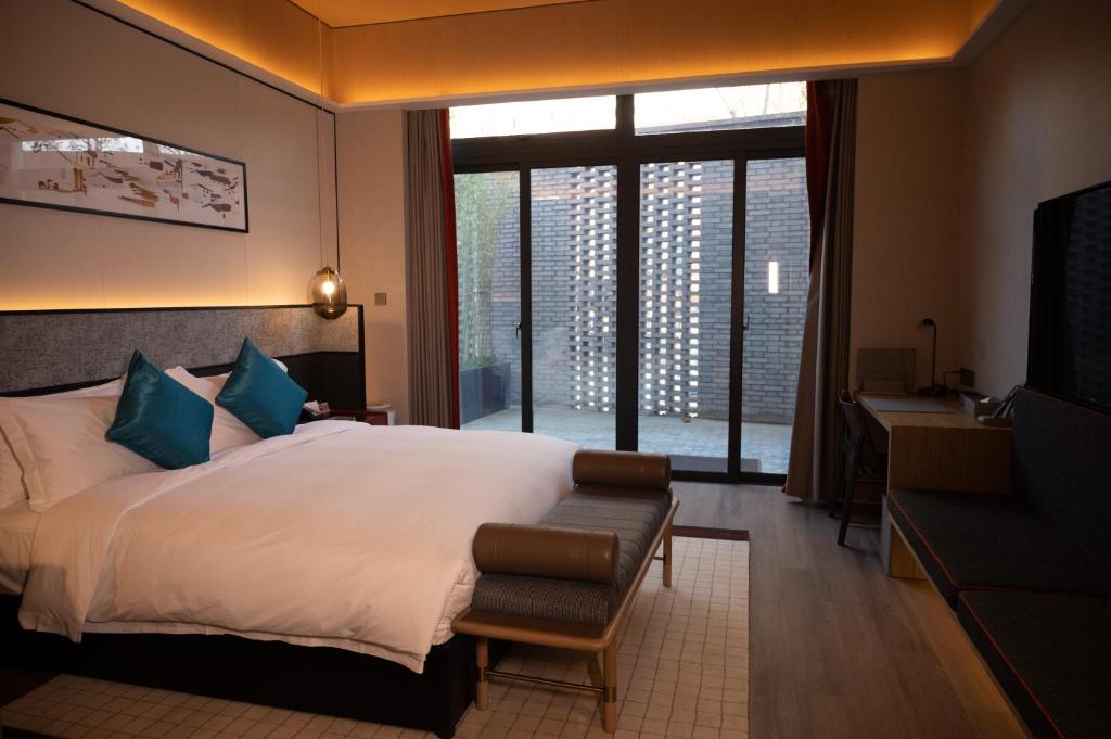 常州市にあるQingguoxiang Wenqi Hotelのベッドとソファとテレビのある寝室