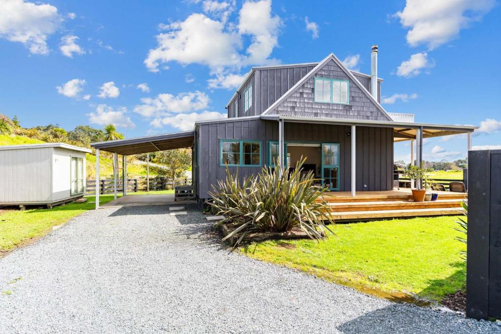 Waipu CoveにあるCove Family Haven - Waipu Holiday Homeのホーム ウィズ ア グレー ハウス ウィズ ア ポーチ