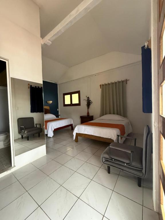 a hotel room with two beds and a mirror at Finca San Antonio in Pluma Hidalgo