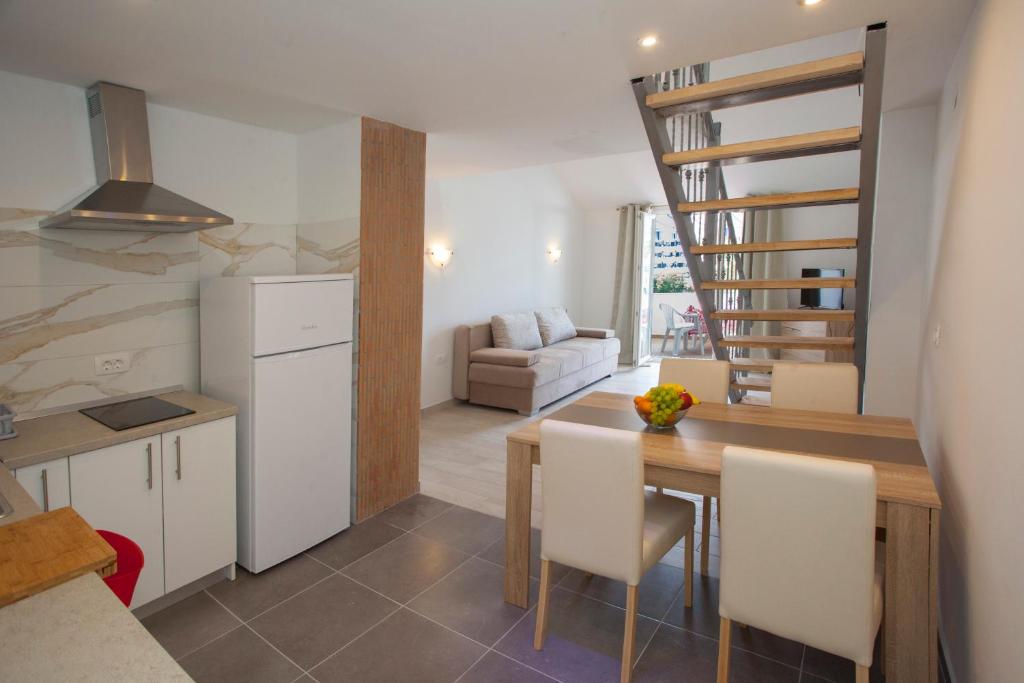 a kitchen and dining room with a table and a staircase at Mar e Sol Apartments in Hvar