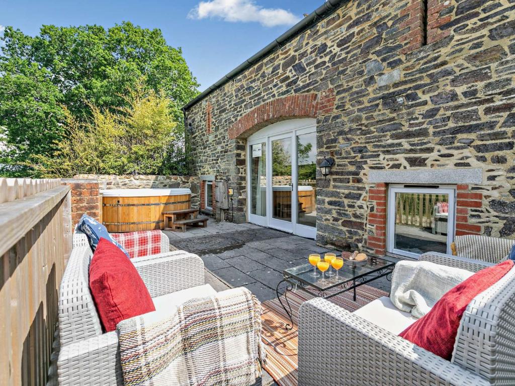 a patio with two white couches and a brick building at 2 Bed in Launceston 92551 in Saint Giles on the Heath