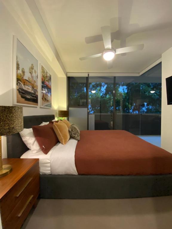 Un dormitorio con una cama grande y un ventilador de techo. en Urban Retreat - Shared Apartment with Queen Bed and Private Ensuite, en Brisbane