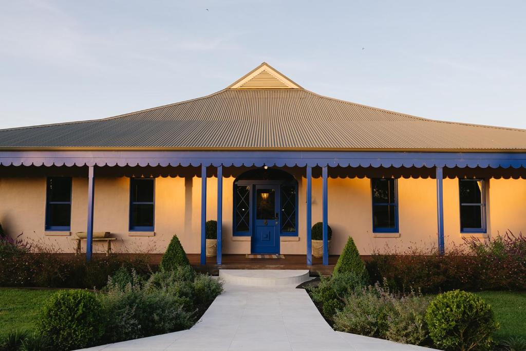 a house with a blue door and a porch at The Sienna Hunter Valley in Luskintyre