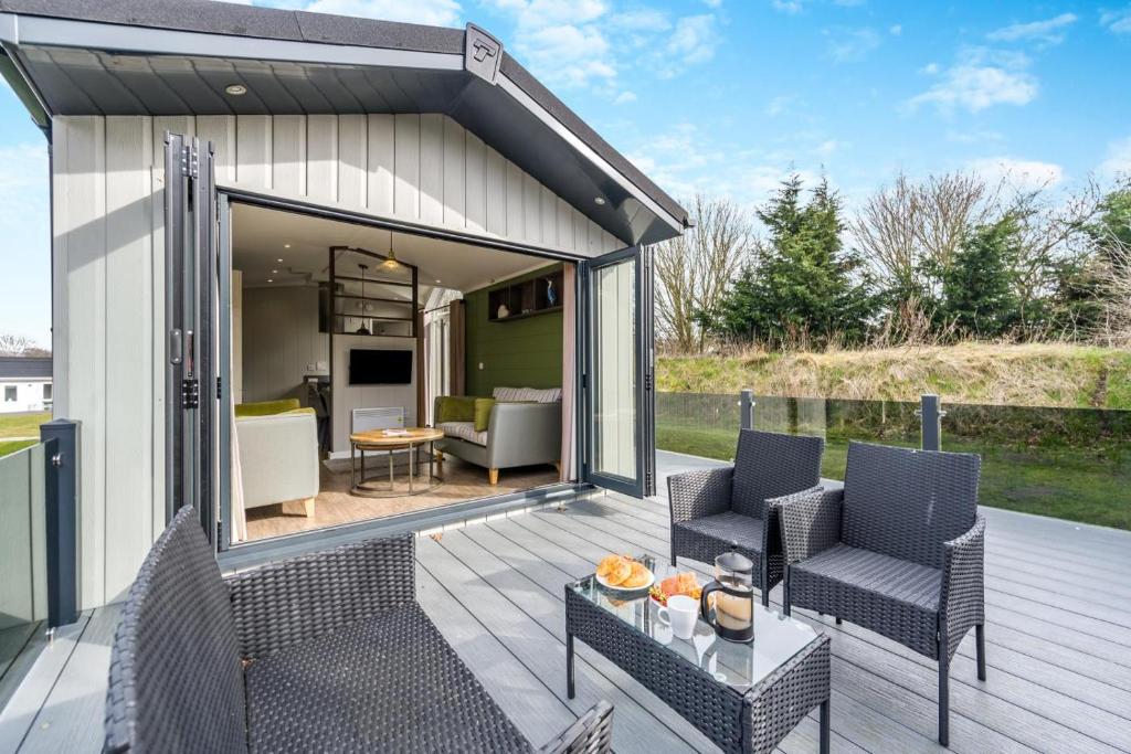 a patio with two chairs and a table on a deck at Marina Retreat in Carlton Colville