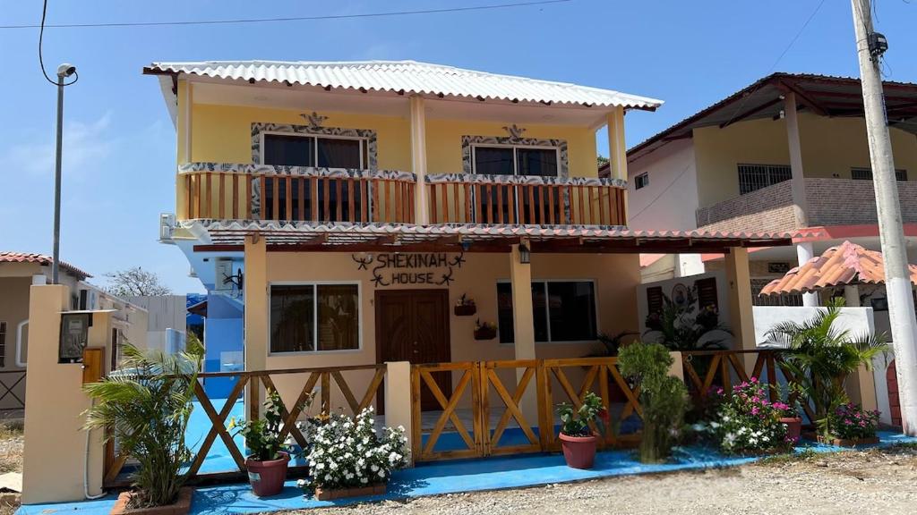 una casa con balcón y flores delante de ella en Alojamiento en Shekinah House, en Data de Villamil