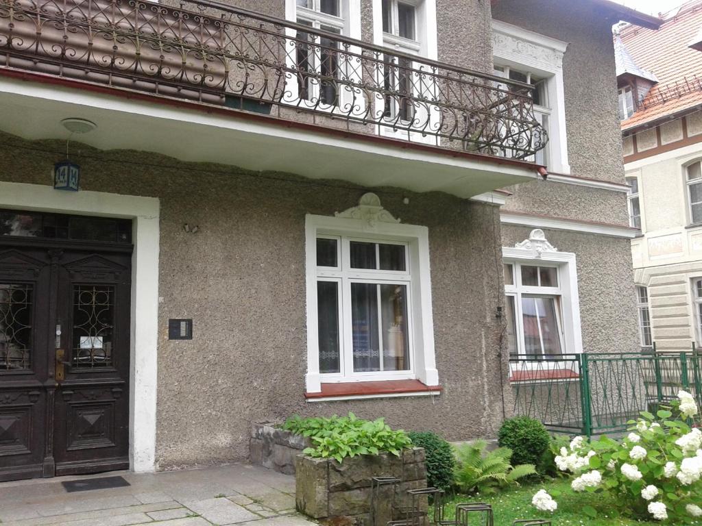 a house with a balcony and a door at Apartamenty KAJA in Kudowa-Zdrój