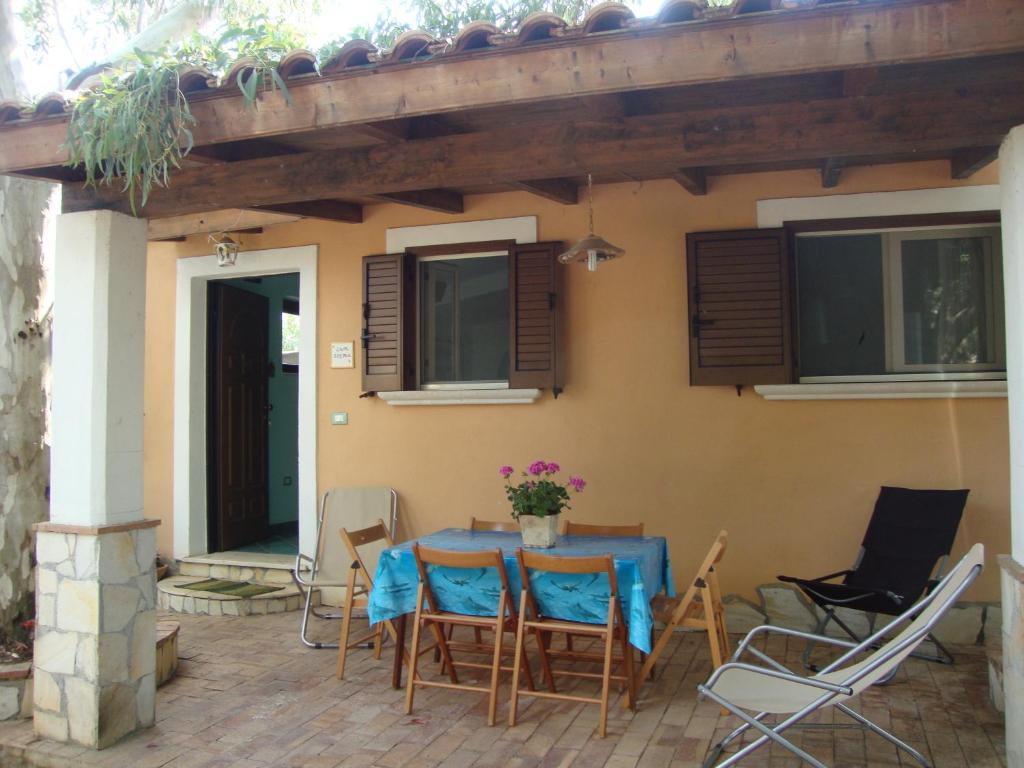 un patio con tavolo e sedie di fronte a una casa di Serena Holiday Home a Marina di Camerota