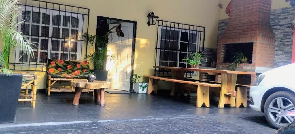 a patio with benches and a chair and a fireplace at Tu hogar en las cataratas in Puerto Iguazú