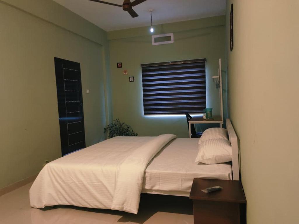 a bedroom with a bed and a window with a fan at Vilstay Go Hill View Residency in Jāmb