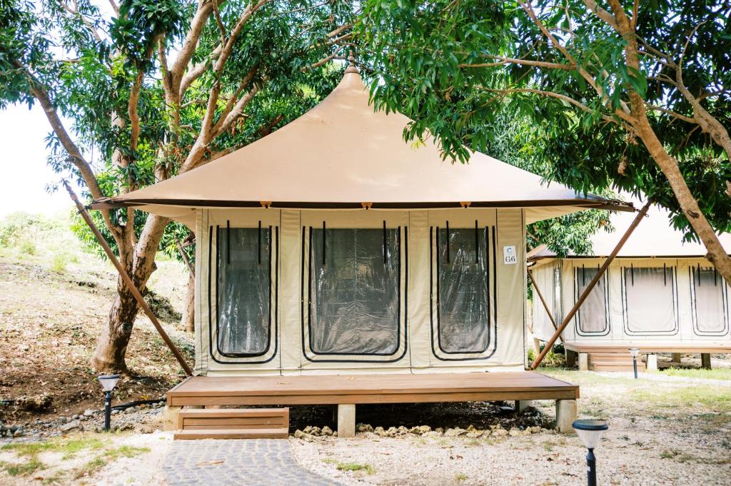 a gazebo with a bench in front of some trees at LasCalas Resort and Luxury Estate in Dasol
