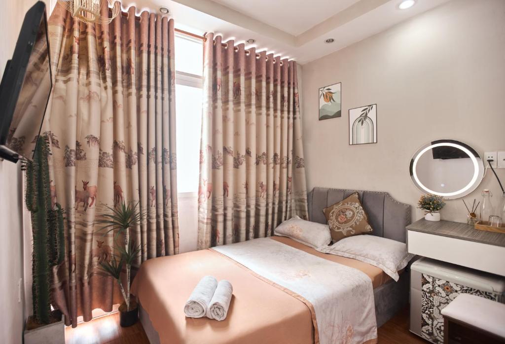 a bedroom with a bed and a window with curtains at H2T Hotel Center BuiVien in Ho Chi Minh City