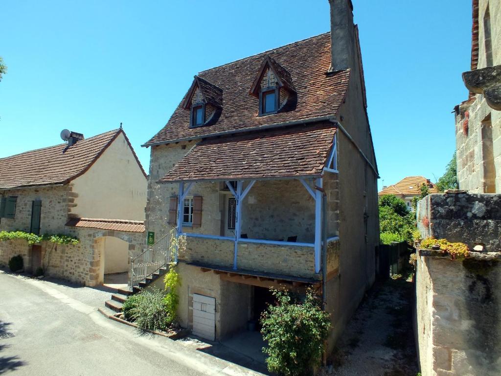 an old house with a roof on a street at L'Oustal dè Pèiro in Le Bourg