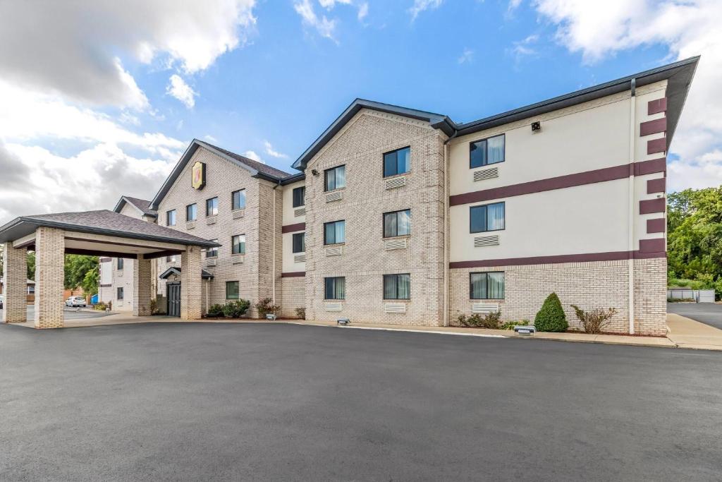 a large building with a parking lot in front at Super 8 by Wyndham Uniontown PA in Uniontown
