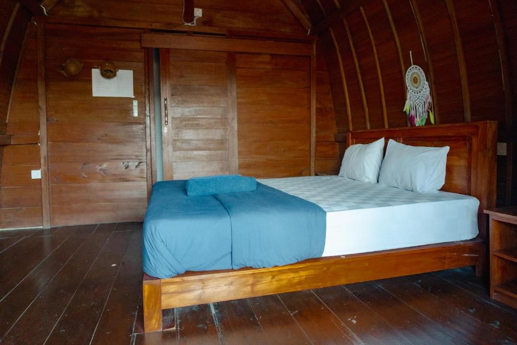 a bedroom with a bed in a wooden room at Naughty Nest Hostel Bali in Canggu