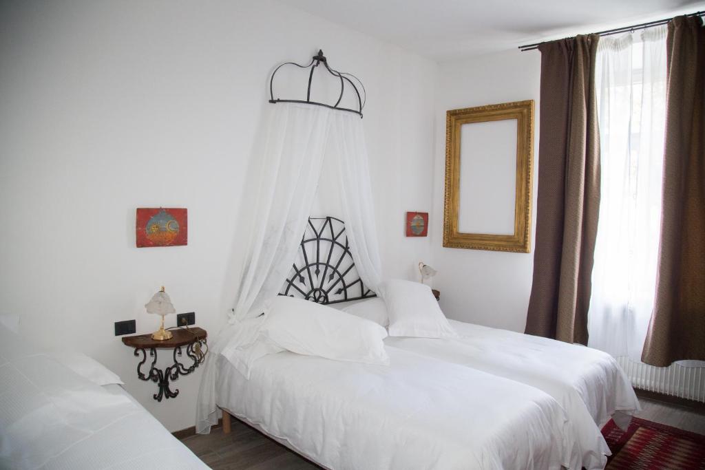 a bedroom with two white beds and a window at B&B La Loggia Del Castello in Trento