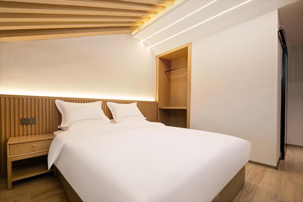 a bedroom with a large white bed in a room at Floral Hotel Yunkexuan in Datong