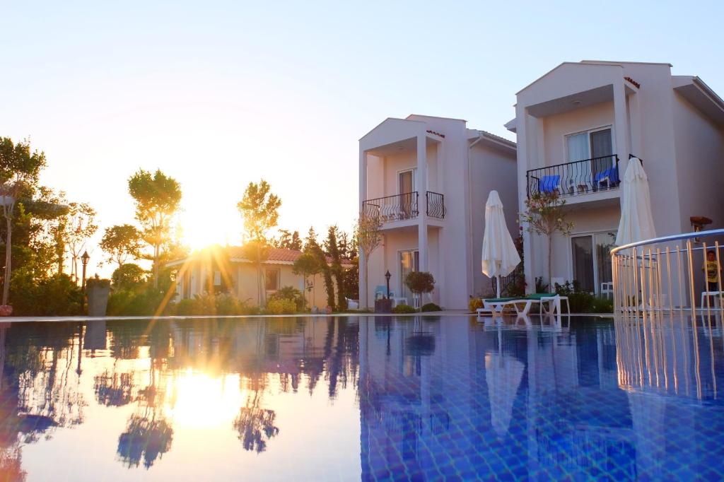 a villa with a swimming pool in front of a building at Kalina Hotel in Datca