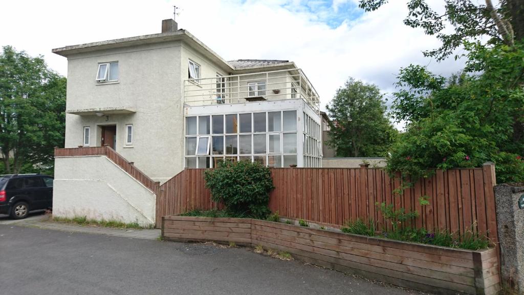 une maison blanche avec une clôture et un portail dans l'établissement Alba Guesthouse, à Reykjavik