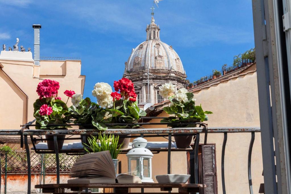 ローマにあるBoutique Domus Navona Librariのバルコニーから花の咲く建物を望めます。