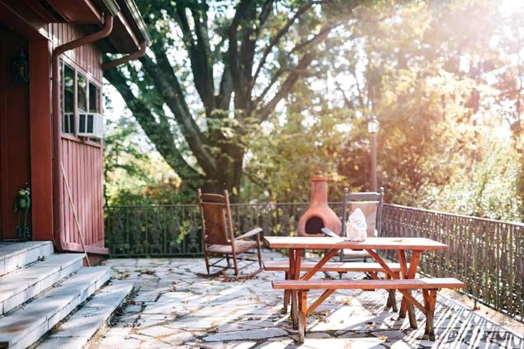 RivertraceにあるRomantic Suite Rental with Terrace and Chimenea near Gatlinburg, Tennesseeのパティオに置かれた木製のテーブルと椅子、そして花瓶