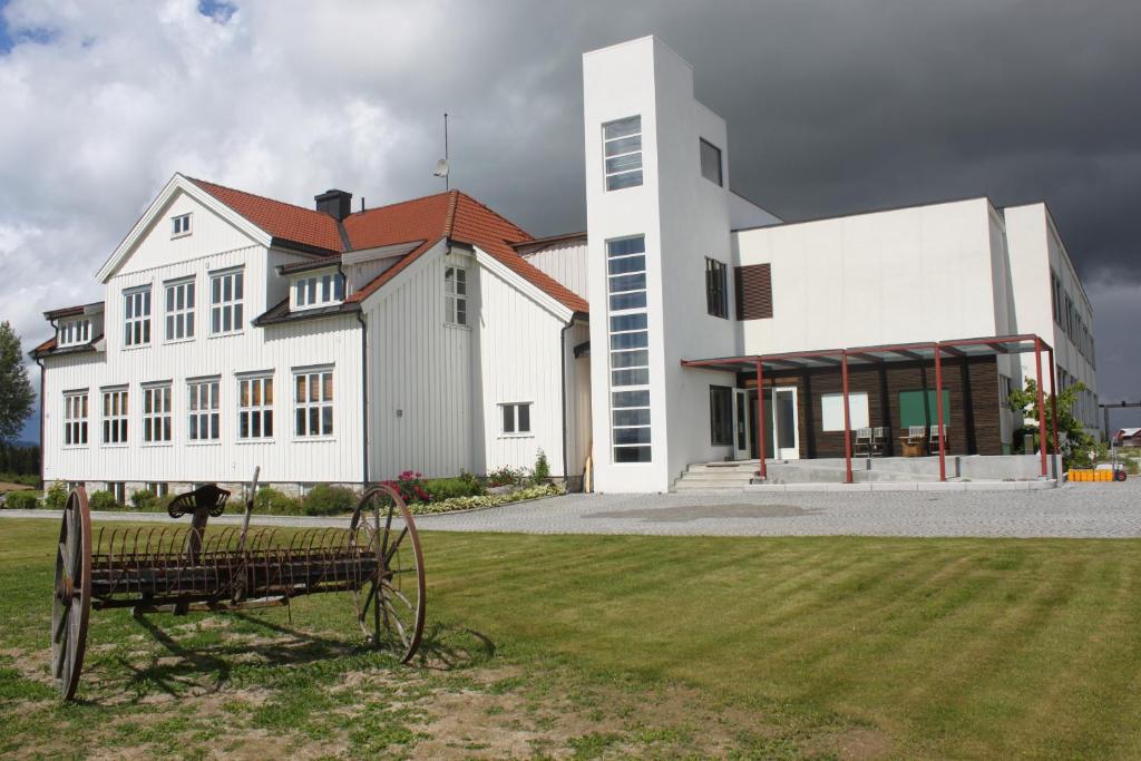 a large white building with a clock in front of it at Elton Hotel in Raufoss