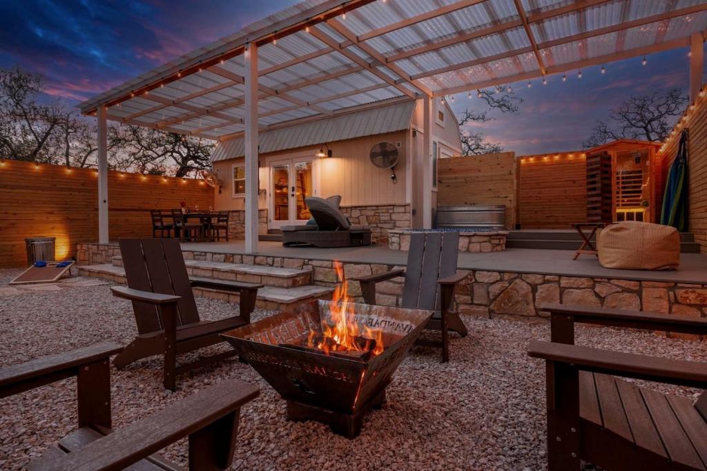 an outdoor patio with a fire pit and a grill at Secluded Luxury Couples Cabin with a Sauna and a Pool, Perfect for a Romantic Weekend in Texas Hill Country in Woodcreek