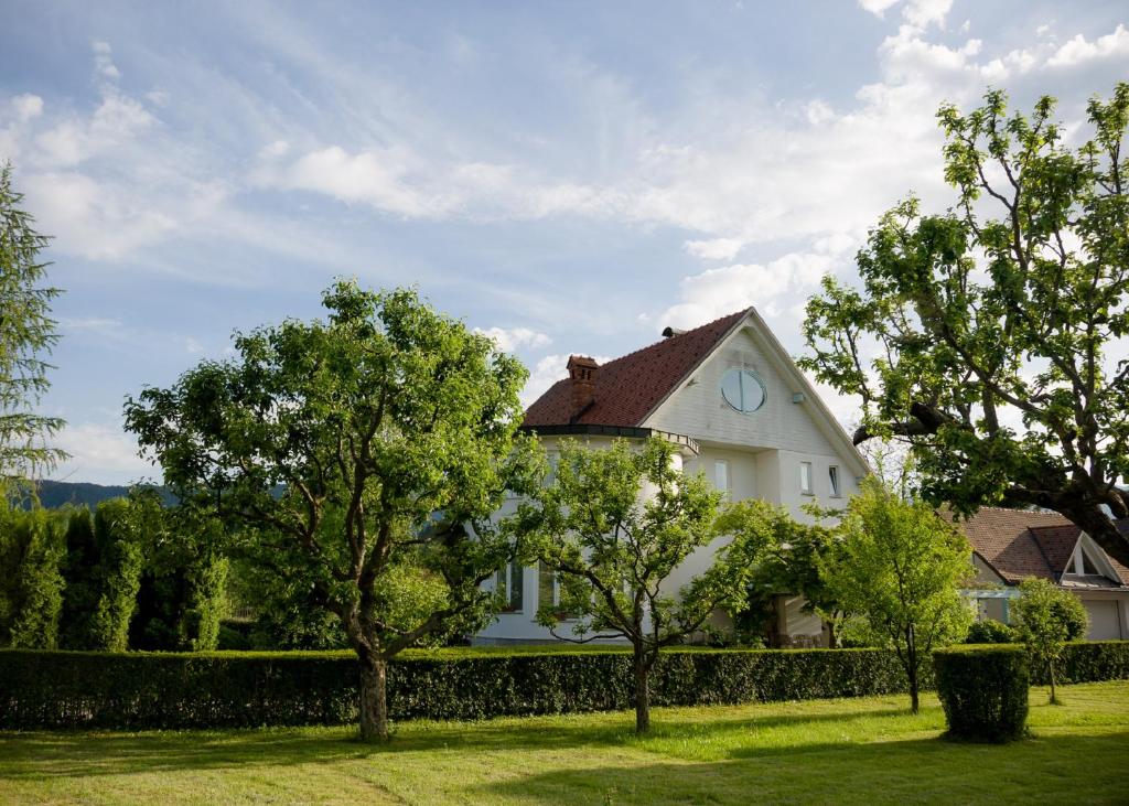 una casa blanca con árboles en el patio en Guest House Vitaja, en Bled