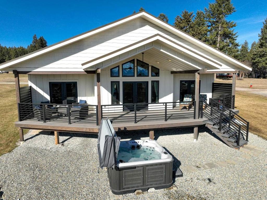 a house with a jacuzzi in front of it at Lake Cabin with Equipped Deck and Hot-Tub in Montana in Lakeside