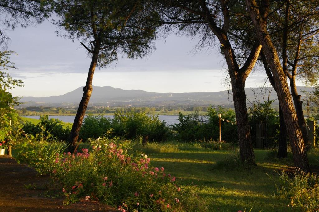 a view of the water from a park with trees and flowers at La Pievaccia in Binami