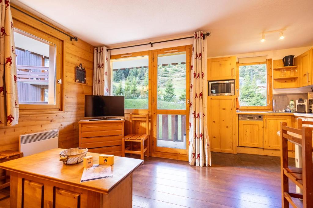 una cucina e un soggiorno con un tavolo e una TV di Cimes 2 #21 - 6 guests a Méribel
