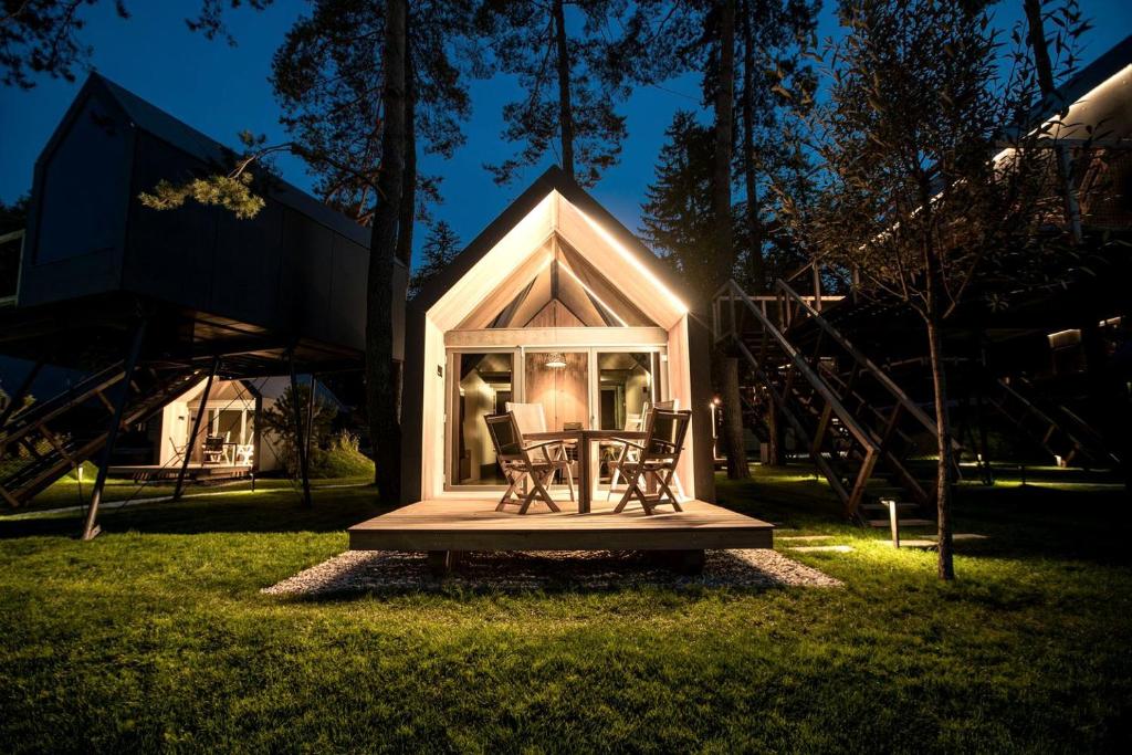 a tiny house with a table and chairs in the grass at Luxurious Cabin Rental with a Hot Tub near Maribor for Glamping in Slovenia in Brestrnica