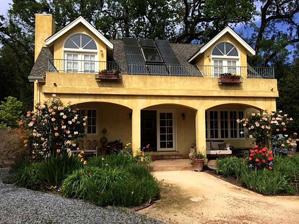ein gelbes Haus mit Blumen davor in der Unterkunft Romantic Getaway Cabin with a Pool and a Hot Tub in the Heart of Sonoma, California in Glen Ellen
