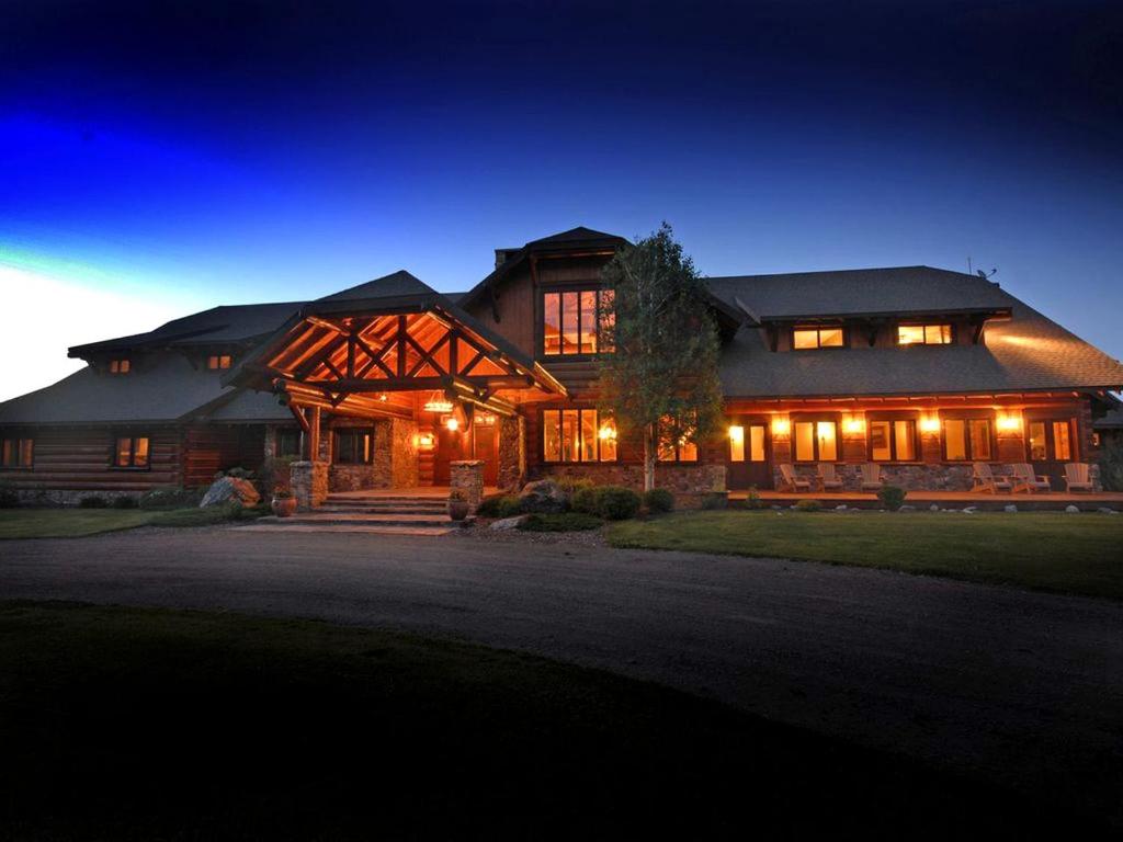 a large house at night with the lights on at Deluxe Vacation Suite with Private Bathroom in Melrose, Montana in Divide
