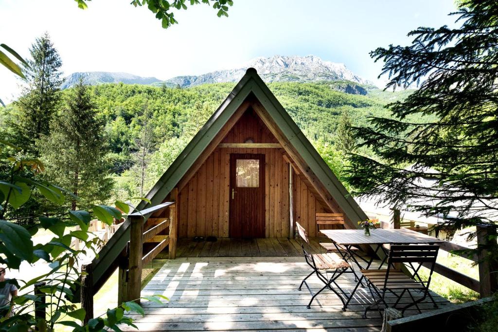 a small cabin with a table and a table at Inviting Room Rental for a Vacation in the Stunning Setting of Soca, Slovenia in Soča