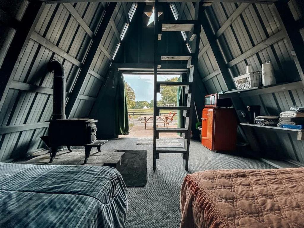 - une chambre avec une cheminée et un lit dans l'établissement Secluded A-Frame Glamping on 46-Acre Farm Near Nashville – Queen Beds, Fire Pit, Breakfast Included, à Lebanon