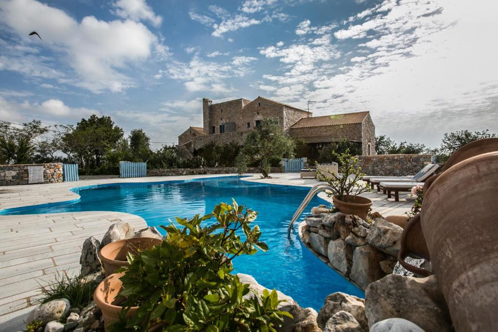 una piscina de agua azul en un patio en Ktima Karageorgou en Areopolis